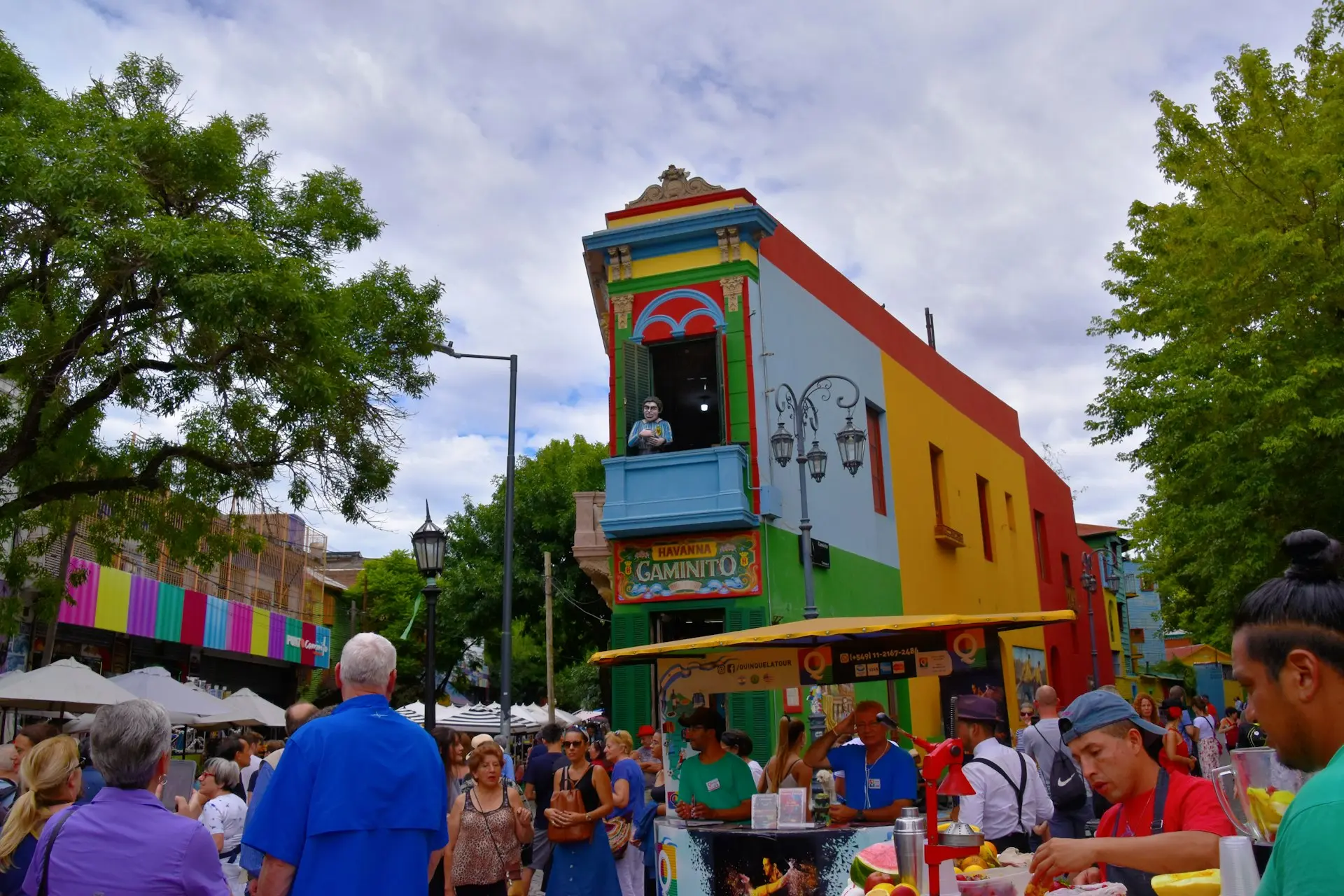 a group of people standing in front of a colorful building